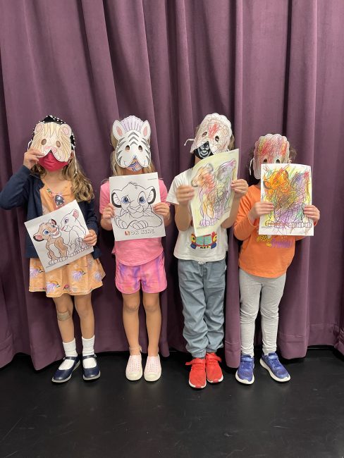 Kids with craft animal masks and drawings