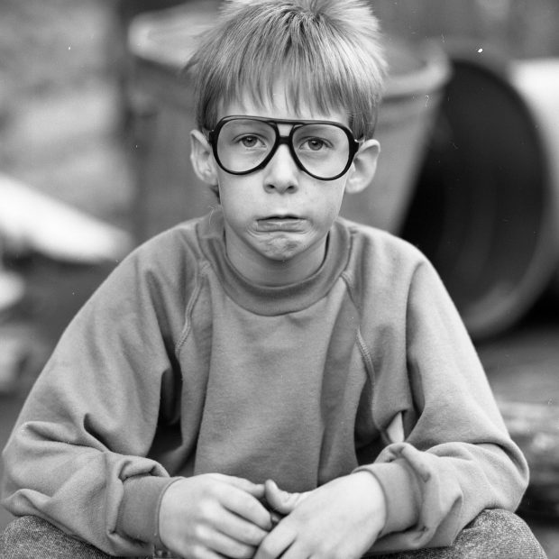 Kid wearing glasses and sweatshirt in black and white