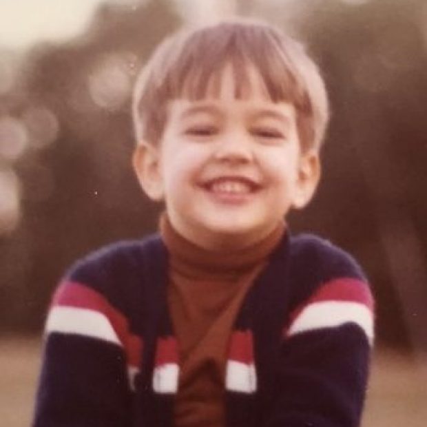Young boy smiling with turtleneck on