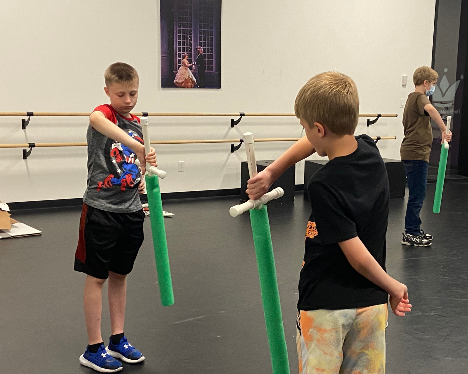 two boys learning to use prop sword