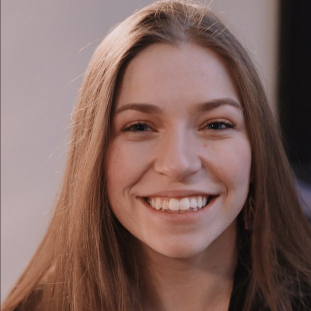 Young woman smiling with neutral background