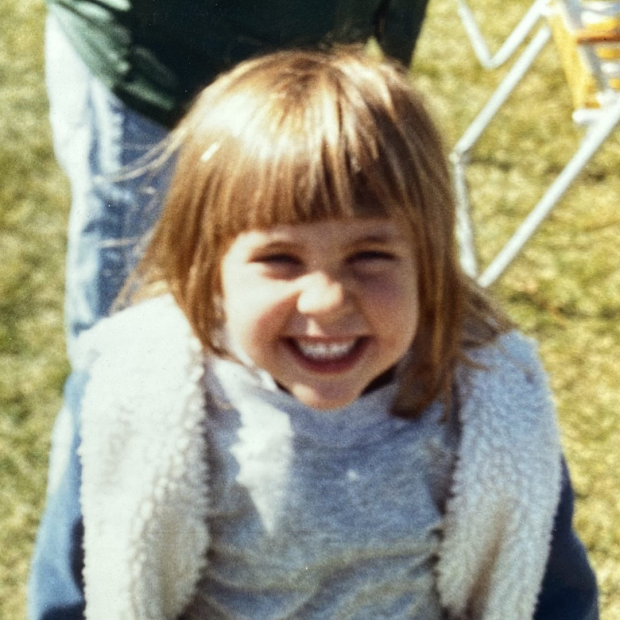 Young girl smiling with bangs and a grey shirt with a Sherpa jean jacket