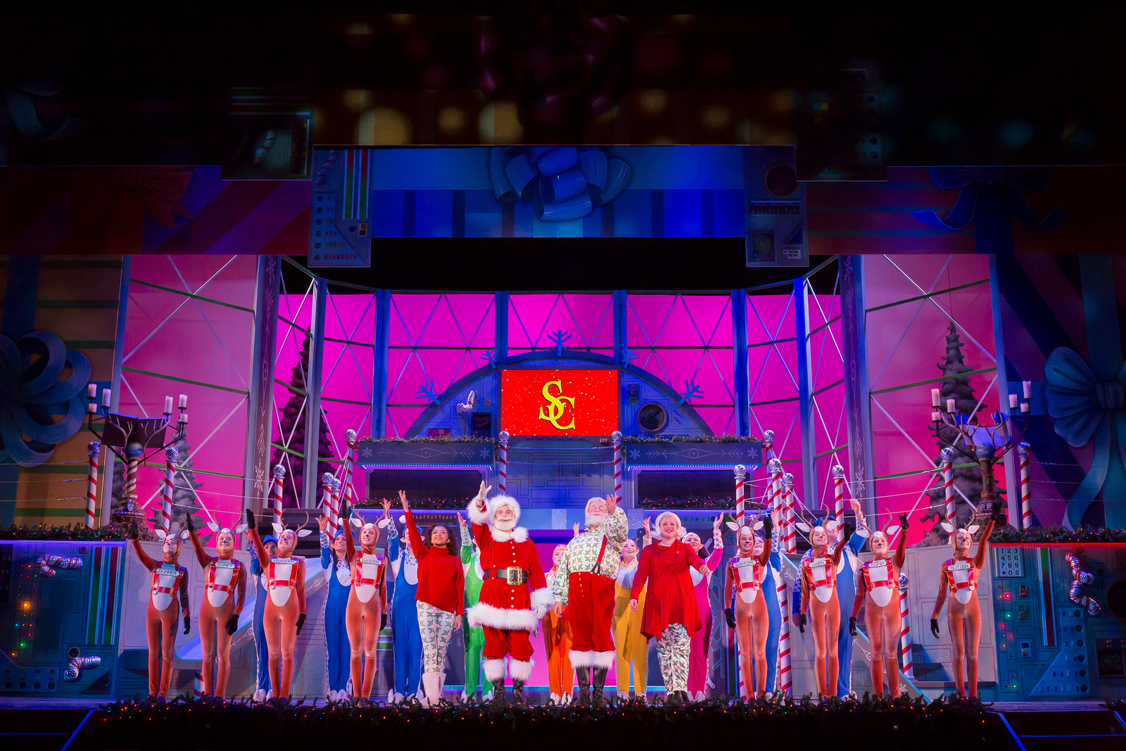 Santa and reindeer bowing on stage